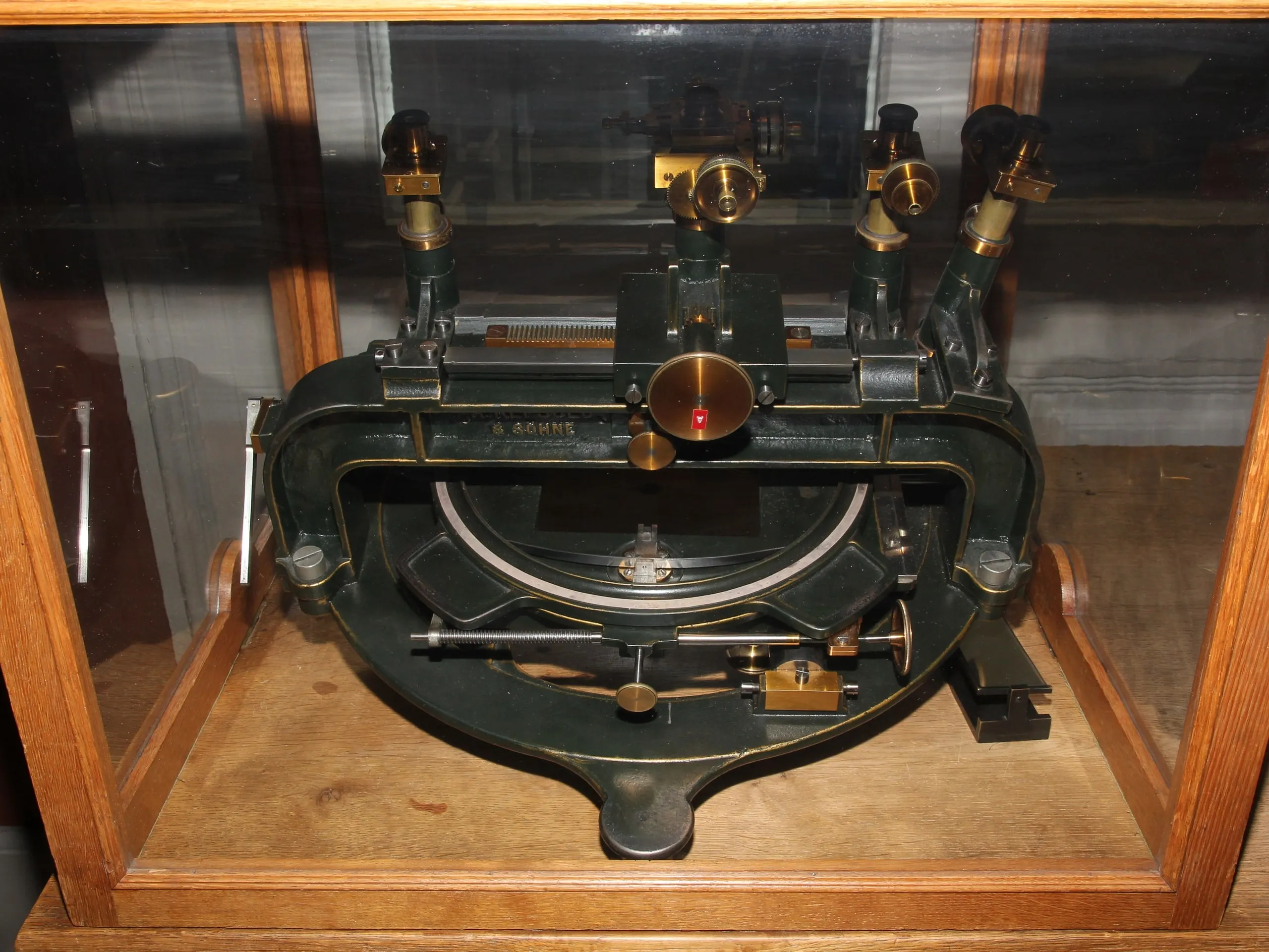 A heavy cast-iron instrument with brass eyepieces and a curved scale, used to measure star positions on glass plates.